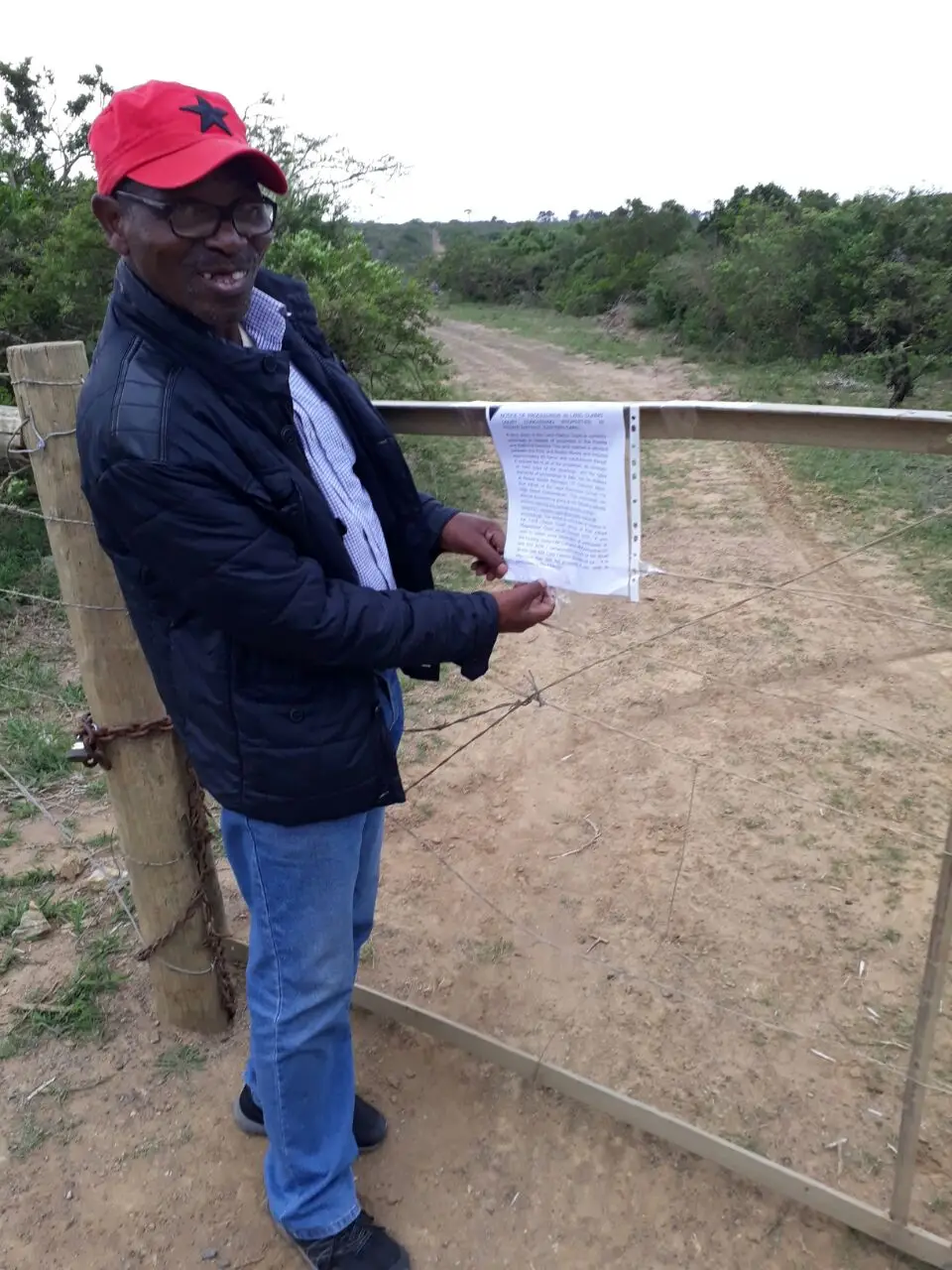 Figure 2: Mr Gladman Tom posing with a notice to one of the affected land owners